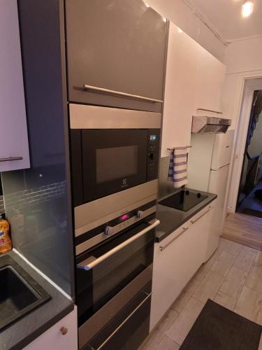 une cuisine avec un évier et un micro-ondes dans l'établissement Charmant appartement près de Montmartre 2, à Paris