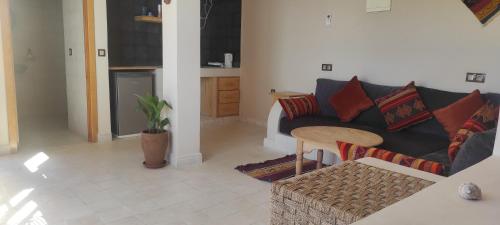 a living room with a couch and a table at SurfAppart Morocco in Tamraght Ouzdar
