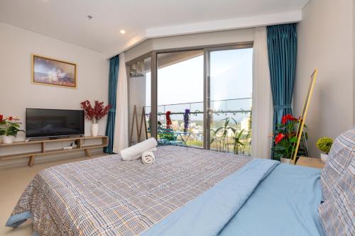 a bedroom with a bed and a large window at The Sóng luxury apartments in Vung Tau in Vung Tau