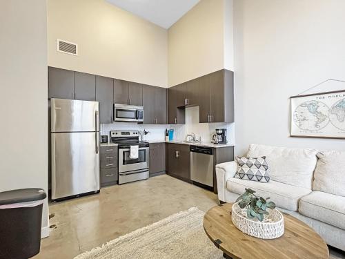 a living room with a couch and a kitchen at Large 1 Bed apt in the Heart of Downtown in Des Moines