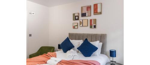 a bedroom with a bed with blue pillows at Tranquil Retreat in Hendon: Comfort & Style Await in The Hyde