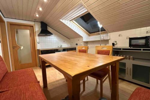 a large kitchen with a wooden table and chairs at Apartment Oase 2, Parkplatz, Küche, Internet in Klosterlechfeld