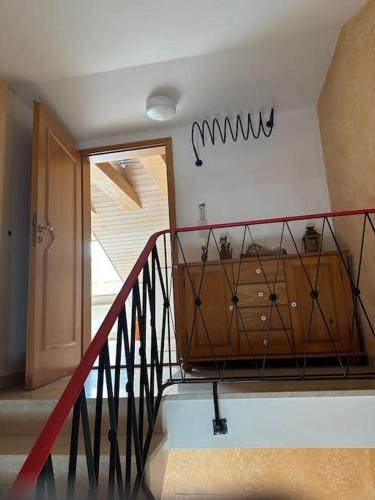 a staircase with a red railing and a wooden cabinet at Apartment Oase 2, Parkplatz, Küche, Internet in Klosterlechfeld