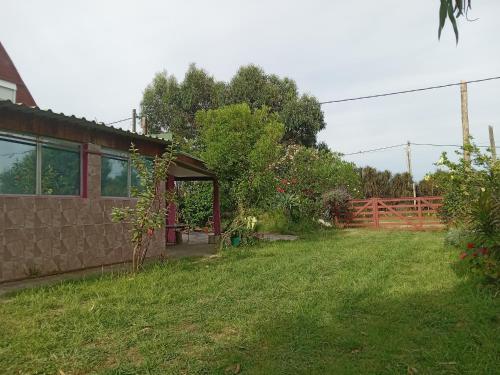 un patio trasero de una casa con un patio verde en LAPOSTa555 en Piriápolis