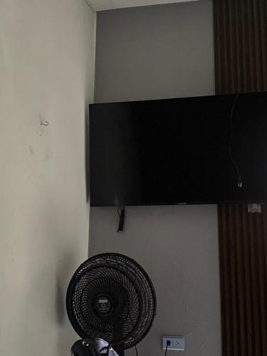 um ventilador preto está pendurado numa parede em Departamento Basico em Guayaquil