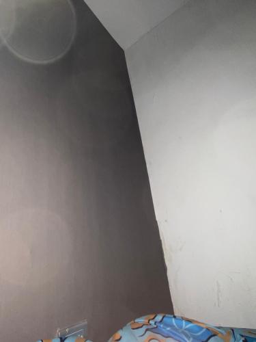 um canto de um quarto com uma parede cinzenta em Departamento Basico em Guayaquil