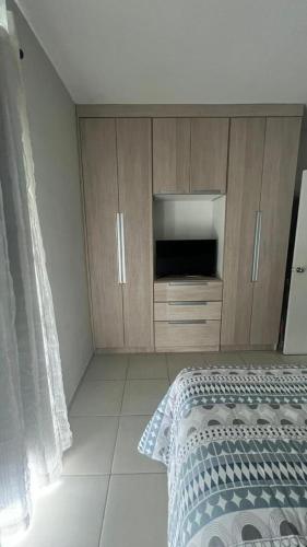 1 dormitorio con 1 cama y armarios de madera en Flat Aldeia Das Águas Village en Barra do Piraí