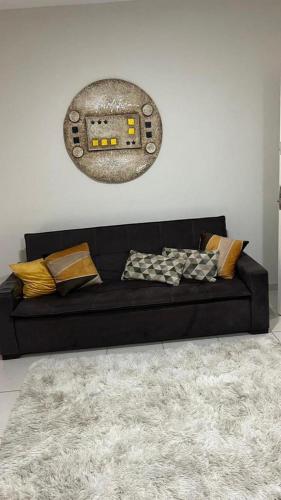 Sofá negro en una sala de estar con alfombra en Flat Aldeia Das Águas Village en Barra do Piraí