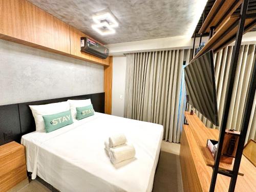 um quarto com uma cama com uma cadeira em STAY ID Vida Urbana em Goiânia