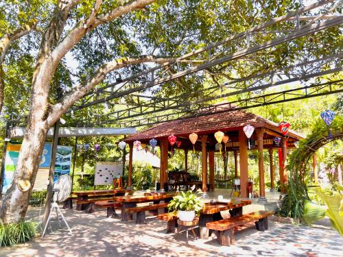 ein Pavillon mit Holztischen in einem Park in der Unterkunft Ninh Binh Family Homestay in Ninh Bình