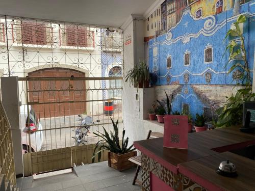 um restaurante com um mural na parede e plantas em Solar dos Poetas em São Luís