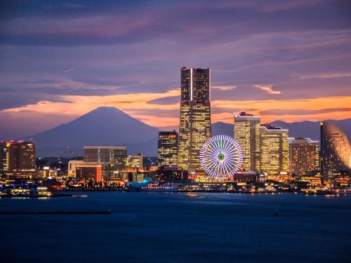 eine nächtliche Aussicht auf eine Stadt mit einem Riesenrad in der Unterkunft APA Hotel Yokohama Kannai in Yokohama