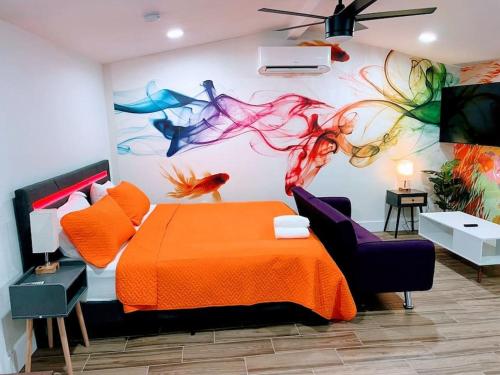 a bedroom with an orange bed and a painting on the wall at Phoenix Retreat - Studio with King Bed - 10 min from Airp - Unit C in Phoenix