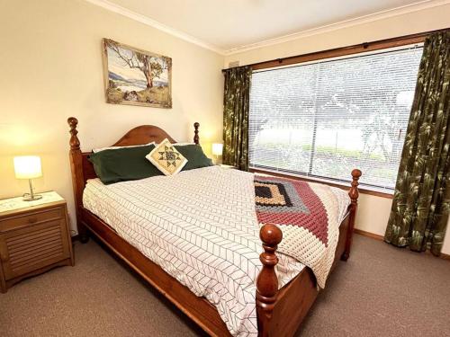 a bedroom with a bed and a large window at Grassvale Farms Retreat - Lodge in Lindenow