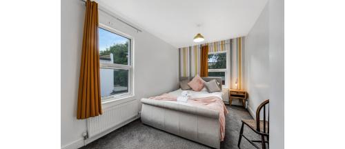 sala de estar con sofá y ventana en Spacious Two Bedroom Apartment in Wood Green en Londres