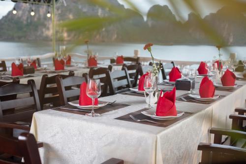 下龙湾Ruby Cruise的一组摆放着红色餐巾和酒杯的桌子