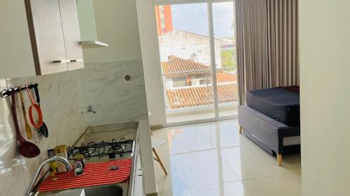 a kitchen with a stove top oven next to a window at Aparta estudio el peñón 4.3 in Cali