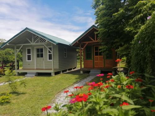 a tiny house in a garden with flowers at Casitas Jacaranda in Savegre