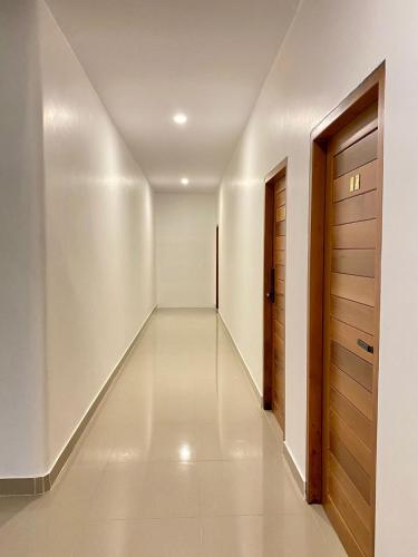 a hallway with white walls and a wooden door at B2 Hotel Savannakhet in Savannakhet