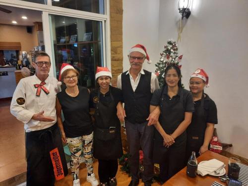 a group of people in front of a christmas tree at Meyers Hua Hin in Hua Hin