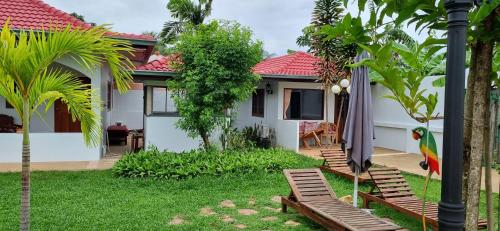 a house with a yard with chairs and an umbrella at Meyers Hua Hin in Hua Hin