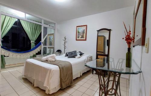 Schlafzimmer mit einem Bett, einem Tisch und einem Spiegel in der Unterkunft Descanse na rede da varanda em um local nota 10 e Wi Fi top! in Brasilia