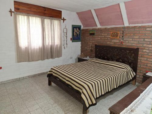 een slaapkamer met een bed en een bakstenen muur bij Paraíso de Mayú in San Antonio de Arredondo