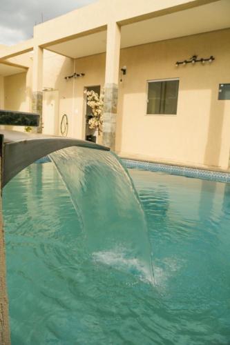 - une piscine avec un point d'eau dans une maison dans l'établissement Damissele, à Betim
