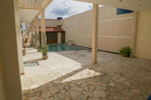 une terrasse avec une piscine dans une maison dans l'établissement Damissele, à Betim