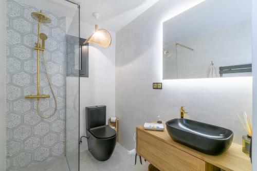 uma casa de banho com um lavatório preto e um chuveiro em En Calma por el Mediterráneo. em Sant Adria de Besos