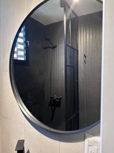een spiegel in een badkamer met een douche bij Duplex Las magnolias Villa allende in Villa Allende