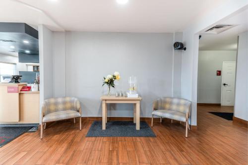 a table with two chairs and a vase of flowers on it at TownePlace Suites Fredericksburg in Fredericksburg