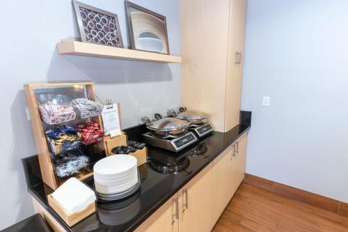 a kitchen with a stove and some dishes on a counter at TownePlace Suites Fredericksburg in Fredericksburg