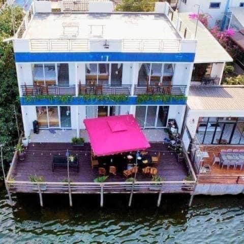 a large house on the water with a pink roof at Vimean Dong Prek in Kampot