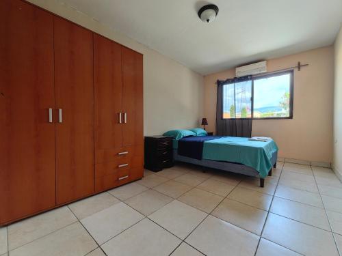 a bedroom with a bed and cabinets and a window at Casa Céntrica Comayagua in Comayagua