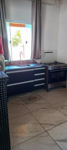 a kitchen with a sink and a stove at Casa de praia in Estância