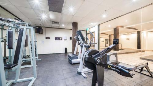 a gym with a treadmill and tread machines at Oaks Sydney Goldsbrough Suites in Sydney