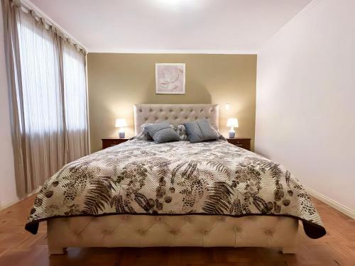 1 dormitorio con 1 cama, 2 lámparas y ventana en Apartamento en la mejor ubicación, centro de Loja, en Loja