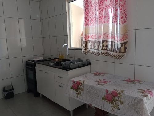 a small kitchen with a sink and a table at Kitnets Recanto Caiobá in Matinhos