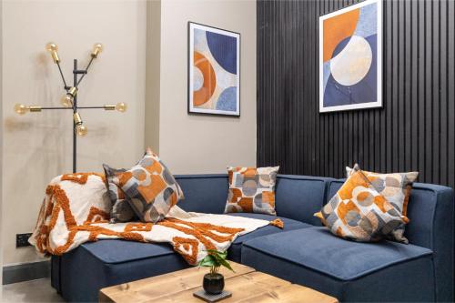 a blue couch with pillows on it in a living room at Modern & Funky 3-BR Duplex with Games Room & Sauna in London