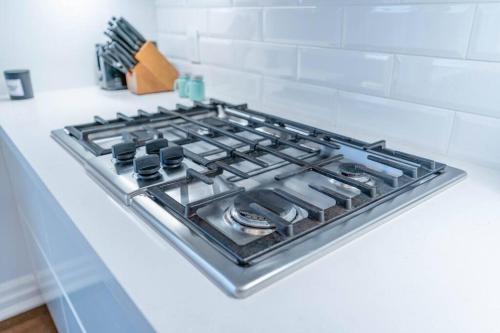 a stove top oven sitting on top of a counter at Luxurious & Modern 4BR House w/ 3 Car Parking in Burlington