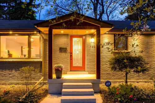 a brick house with a red door and stairs at Luxurious & Modern 4BR House w/ 3 Car Parking in Burlington