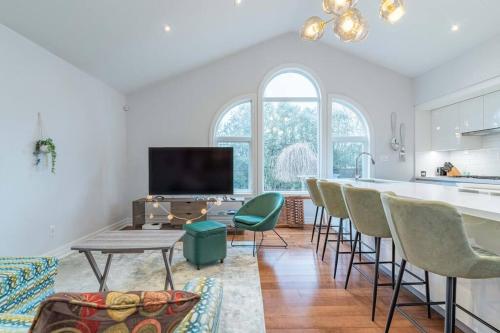 a living room with a kitchen and a table and chairs at Luxurious & Modern 4BR House w/ 3 Car Parking in Burlington