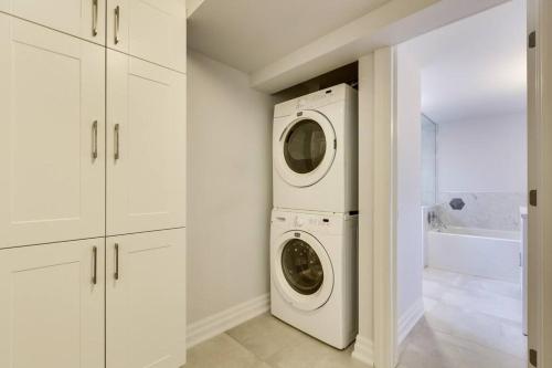 a white laundry room with a washer and dryer at Luxurious & Modern 4BR House w/ 3 Car Parking in Burlington