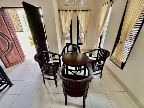 a dining room with a wooden table and chairs at Bidel's House in Gianyar