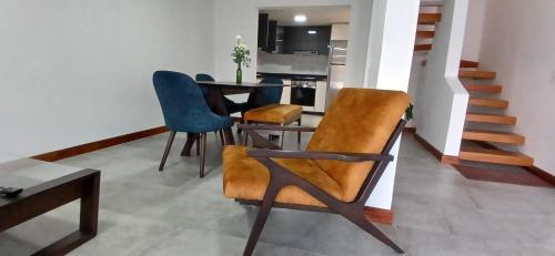 a living room with a table and chairs and a staircase at CasAvella Paipa in Paipa