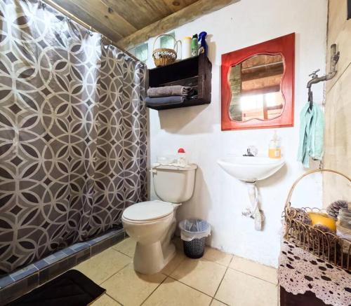 a bathroom with a toilet and a sink at Cabaña Colibrí in Santa Cruz Verapaz