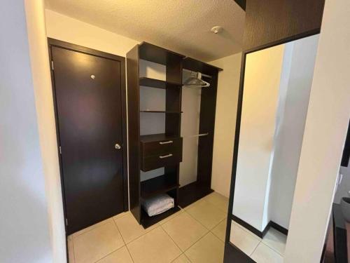 a bathroom with a closet with a black door at Nice Apartment in Zone 4 in Guatemala