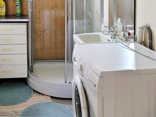 a bathroom with a sink and a washing machine at Holiday home Nordfold in Nordfold