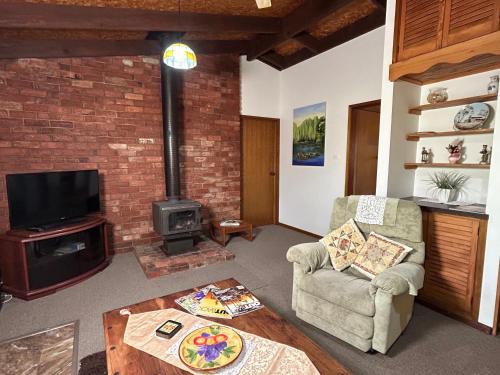 a living room with a couch and a stove at Grassvale Farms Retreat - Lodge in Lindenow